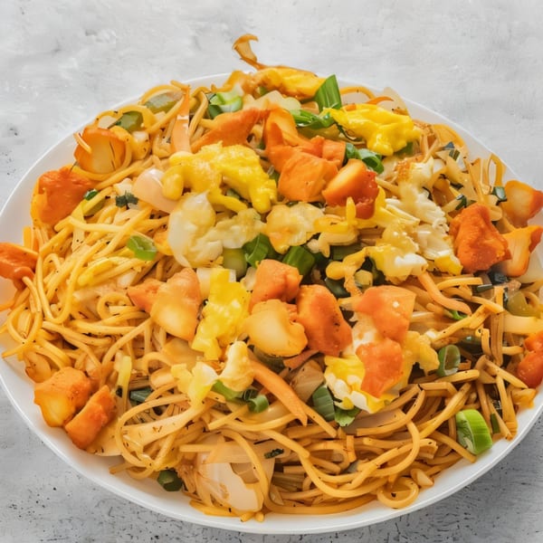 Kadai Indian Kitchen's chicken noodles with egg, chicken, and vegetables on a white plate.